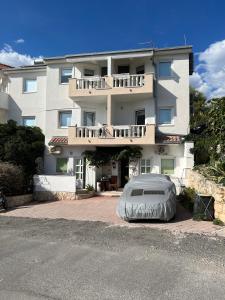 a large white building with a cover in front of it at Apartmani Levarda in Trogir
