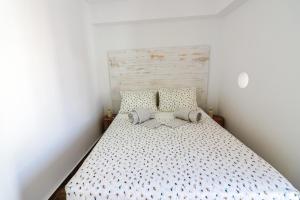 um pequeno quarto com uma cama e uma cabeceira em madeira em Refúgio da Fortaleza em Sesimbra