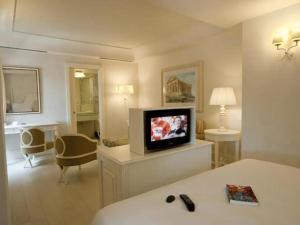 a hotel room with a television and a bed at Hotel Villa Athena in Agrigento