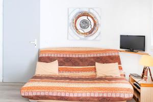 1 dormitorio con sofá y TV en Appartement La Coline Bleue, en Biarritz