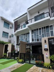 an apartment building with a green lawn in front of it at Boxsoon Nimman 3 # 4beds 4baths in Chiang Mai