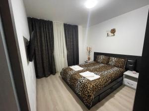 a bedroom with a leopard print bed in a room at Apartament ELLA in Tulcea