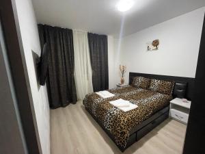 a bedroom with a leopard print bed in a room at Apartament ELLA in Tulcea