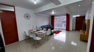 a dining room and living room with a table and chairs at Departamentos amoblados en Huánuco in Huánuco