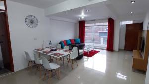 Departamentos amoblados en Huánuco في هانوكو: غرفة معيشة مع طاولة طعام وكراسي