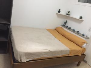 a bed in a room with a white wall at L’esprit libre in Lacaune