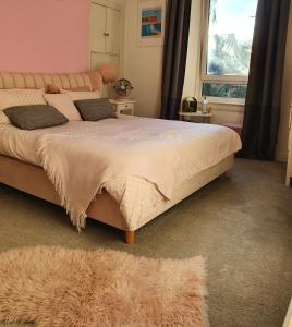 ein Schlafzimmer mit einem großen Bett und einem Fenster in der Unterkunft The Flat with the Pink Door in Edinburgh