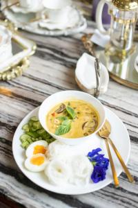 un tazón de sopa y huevos en un plato en Srisanor Boutique Hotel en Prachuap Khiri Khan