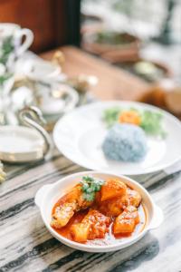 un plato de comida en una mesa con dos platos de comida en Srisanor Boutique Hotel en Prachuap Khiri Khan