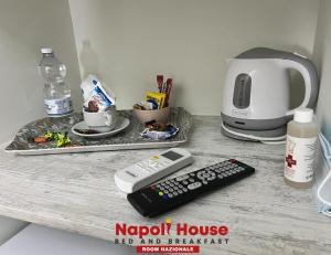 um balcão com controlo remoto e comodidades para preparar café em B&B Napoli House em Nápoles