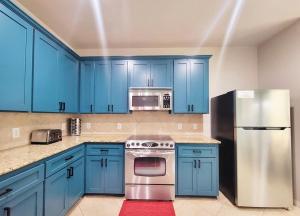 a kitchen with blue cabinets and a stainless steel refrigerator at Rack'em Up 6 beds Pool Table GRB Downtown in Houston