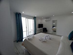 una camera da letto con un letto con due asciugamani bianchi di Appartamenti Tropea Gargano a Parghelia