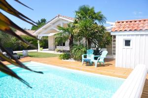 a pool with two chairs and a house at Maison avec piscine, jaccuzi, hammam à 800 m du lac in Gastes