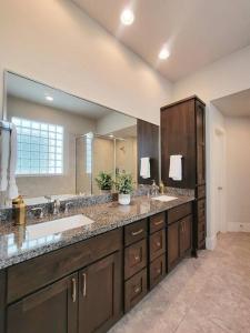 un bagno con due lavandini e un grande specchio di The Posh Haus - Downtown - GRB - King Bed a Houston
