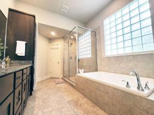un ampio bagno con vasca e doccia di The Posh Haus - Downtown - GRB - King Bed a Houston