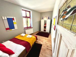 a small bedroom with a bed with a yellow blanket at Red&Yellow Apartments Centrum in Olsztyn