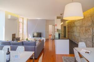 ein Wohnzimmer mit einem Sofa und einem Tisch in der Unterkunft Feel Porto Ribeira Vintage Duplex in Porto