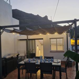 een patio met een tafel met stoelen en een parasol bij Santiago del Teide Room in Santiago del Teide