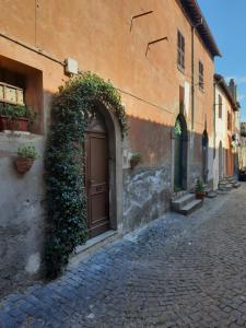 un ingresso a un edificio con porta e edera di La Casa del Pellegrino a Tuscania