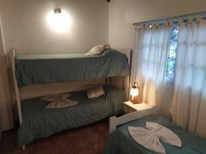 a bedroom with two bunk beds and a window at Tierra Mora Casas de alquiler, ESTA PROPIEDAD SE GESTIONA SOLO POR ESTA PAGINA, SOLO GRUPOS FAMILIARES in Villa Gesell