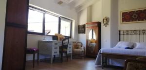 a bedroom with a bed and a desk and a window at CURATO EL HORNO in Trefacio