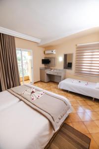 una camera d'albergo con due letti e una televisione di Hotel Alrawabi a Nefza