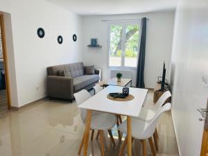ein Wohnzimmer mit einem Tisch, Stühlen und einem Sofa in der Unterkunft Maison proche de Paris/CDG et Disney in Villeparisis