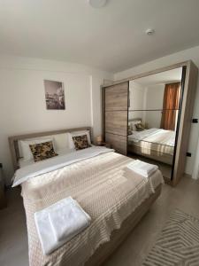 a bedroom with a large bed with a large mirror at Milmari Apartman N92 Kopaonik in Kopaonik +22 photos