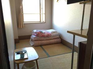 Habitación pequeña con cama para perros y ventana en Asakusa Hotel Fukudaya, en Tokio