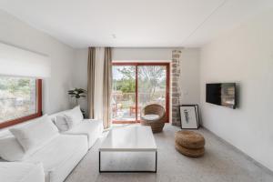 a living room with a white couch and a table at Kampus Luxury Villas in Tríkala