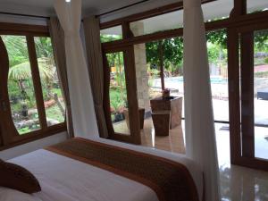 a bedroom with a bed and a view of a pool at The Aroma Villa Munduk in Mayong