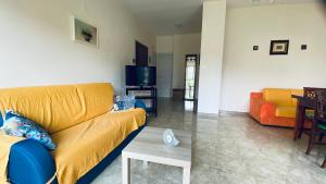 a living room with a yellow couch and a table at Oasi Home in Sulmona