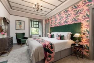 a bedroom with a large bed and a green headboard at Rachel's Farm luxury escapes with Hots Tubs in Buchlyvie