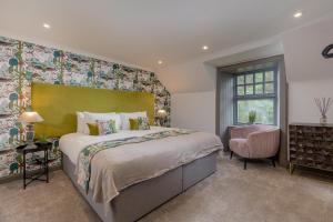 a bedroom with a large bed and a chair at Rachel's Farm luxury escapes with Hots Tubs in Buchlyvie