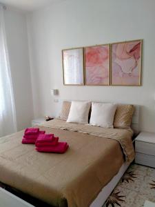 1 dormitorio con 1 cama con 2 toallas rojas en Le Camelie camera, en Bosa