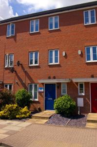 un edificio de ladrillo con una puerta azul y escaleras en Caspian House (4 Bedrooms) en Grimsby