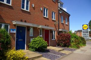 un edificio de ladrillo con una puerta azul en una calle en Caspian House (4 Bedrooms) en Grimsby