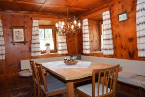 una sala da pranzo con tavolo e sedie in legno di Landhaus Pitztal inklusive Sommercard a Jerzens