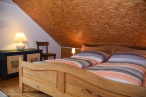 a bedroom with a wooden bed with striped pillows at Landhaus Pitztal inklusive Sommercard in Jerzens