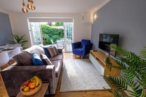 a living room with a couch and a bowl of fruit at Riverwalk Apartment One in Datchet