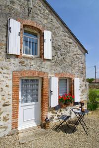 Ce cottage en pierre dispose de portes et de fenêtres blanches. dans l'établissement O Trois Oliviers, à Louin