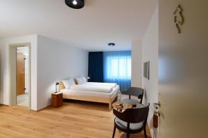 1 dormitorio con 1 cama, 1 mesa y 1 silla en Gasthof zum weissen Rössli, en Erschwil
