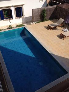 a blue swimming pool with a chair and a chaise at Apartments Villa Dinka in Opatija