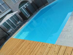 a large blue swimming pool with a wooden deck at Agriturismo Corte Zuccone in Volta Mantovana