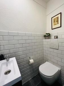 a bathroom with a white toilet and a sink at Das Stader Domizil in Stade