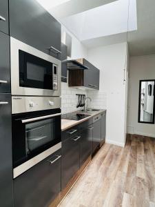 a kitchen with stainless steel appliances and wooden floors at Das Stader Domizil in Stade