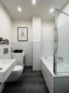 a bathroom with a toilet and a tub and a sink at Das Stader Domizil in Stade