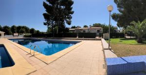 a swimming pool in a yard next to a house at Casa Koala - Bungalow in Moraira - 4 mins playa in Teulada