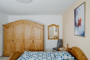a bedroom with a wooden bed and a wooden dresser at Ferienhaus RADO in Winden am See