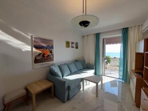 a living room with a couch and a table at Kariani Beach Apartment in Karianí